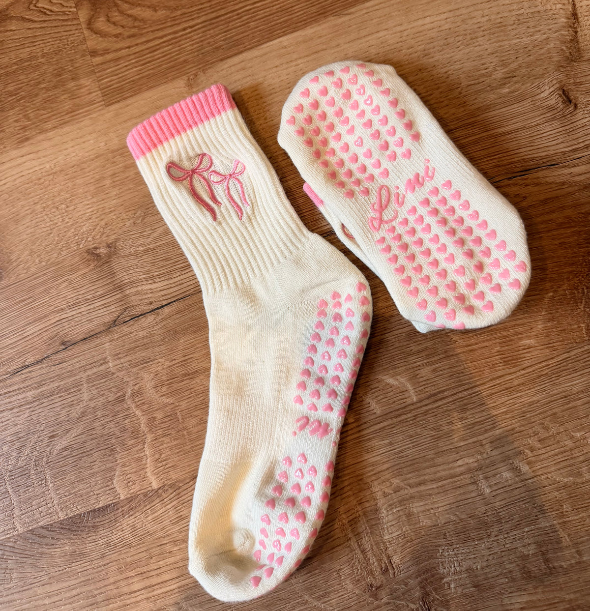 Weiße Pilates Grip Socken von Lini mit pinker Schleifen-Bestickung und Full Sole Grip